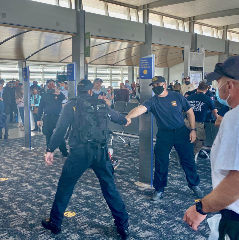 Departing Texas Firefighter Greets His Arriving Replacement, Also from Texas, at Sacramento Int'l Airport